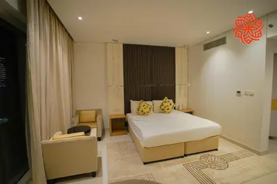 a hotel room with a bed and a chair at Alashrafia Saray- Peaceful studio in Canal Views in Dubai