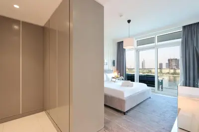 a bedroom with a bed and a large window at 2BR Beachfront Living, Stunning Marina Views in Dubai