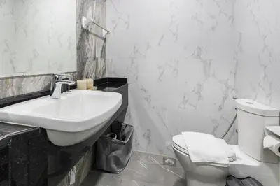 a white bathroom with a sink and a toilet at Studio Apartment featuring Alexa in Elite Residence - Allsopp & Allsopp in Dubai