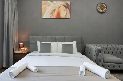 a bedroom with a large bed and a couch at Studio Apartment featuring Alexa in Elite Residence - Allsopp & Allsopp in Dubai