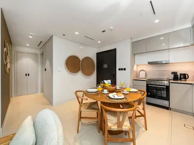 a kitchen and dining room with a wooden table and chairs at Cozy One Bedroom on the Beach in Dubai Harbour - Prestige Retreats in Dubai