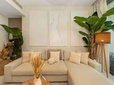 a living room with a couch and some plants at Cozy One Bedroom on the Beach in Dubai Harbour - Prestige Retreats in Dubai