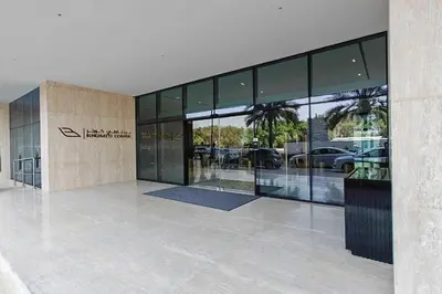 a building with glass windows and a car dealership at Vogue JVC Binghatti Corner near Circle Mall, One Bedroom Apartment with Balcony and City View, Access to all Amenities in Dubai