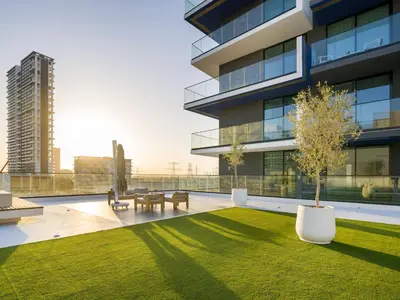 a building with a yard with benches and a tree at Vogue JVC Binghatti Corner near Circle Mall, One Bedroom Apartment with Balcony and City View, Access to all Amenities in Dubai