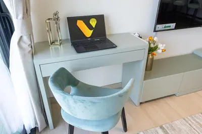 a desk with a laptop and a chair next to a desk at Vogue JVC Binghatti Corner near Circle Mall, One Bedroom Apartment with Balcony and City View, Access to all Amenities in Dubai