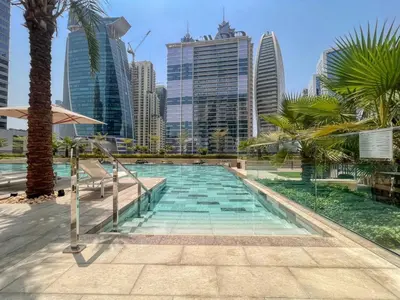 a swimming pool with palm trees and buildings at GuestReady - Business Bay delight in Dubai