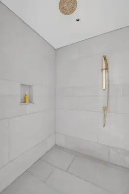 a bathroom with a shower with white walls at Palm Haven Luxe 3 Bed Townhouse with Private Pool in Dubai