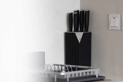 a black refrigerator sitting on a counter next to a wall at Cozy Boho Retreat One Bedroom Sanctuary in Dubai