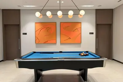 a pool table in a room with two paintings at Elegant Retreat with Stunning Burj Khalifa Views in Dubai