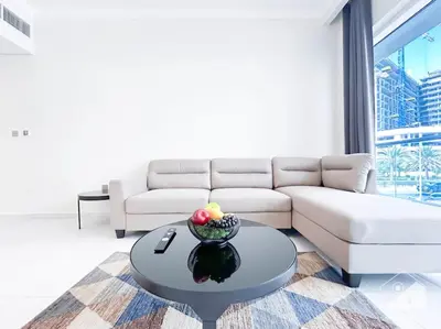 a living room with a couch and a table at Modern 1B with Balcony, Gym & Pool Access in Dubai