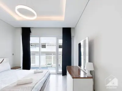 a white bedroom with a bed and a large window at Modern 1B with Balcony, Gym & Pool Access in Dubai