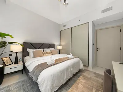 a bedroom with a large bed with two white towels at Designer Large 1 BR with Private Beach Infinity pool in Dubai Harbour in Dubai