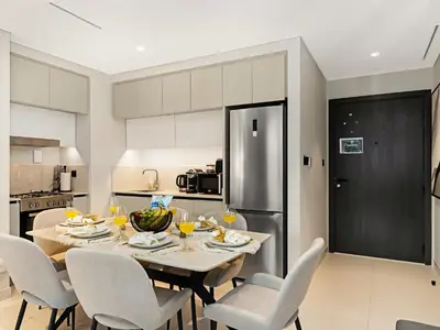 a kitchen and dining room with a table and chairs at Designer Large 1 BR with Private Beach Infinity pool in Dubai Harbour in Dubai