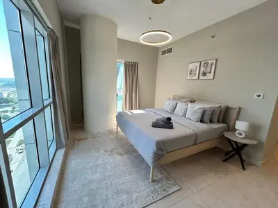 a bedroom with a bed and a large window at 1BR Apt in Business bay close to canal and Dubai mall! in Dubai