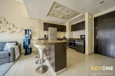 a kitchen with a couch and a table in a room at Contemporary One Bedroom with Full Marina View in Dubai