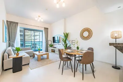 a living room with a table and chairs and a couch at Charming 1BR in Orchid Residence, Al Barsha South by Deluxe Holiday Homes in Dubai