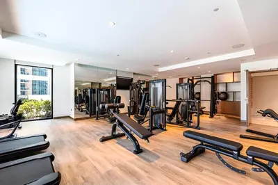a gym with treadmills and elliptical machines at 1BR Act One Act Two T2 City View Downtown in Dubai