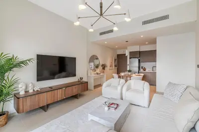 a living room with a flat screen tv and white furniture at 1BR Act One Act Two T2 City View Downtown in Dubai