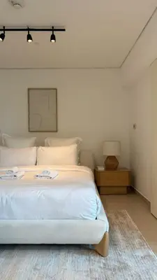 a bedroom with a white bed and a night stand at DAYF-LFT 2 BR in the heart of Downtown walking distance to Burj Khalifa Park in Dubai