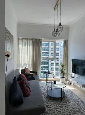 a living room with a couch and a large window at Urban Cozy 1BR apartment with Canal view - Free parking in Dubai