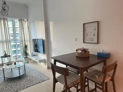 a living room with a dining room table and chairs at Urban Cozy 1BR apartment with Canal view - Free parking in Dubai