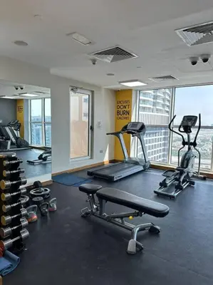 a gym with two treadmills and two exercise bikes at Urban Cozy 1BR apartment with Canal view - Free parking in Dubai