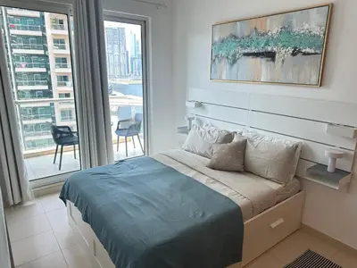 a bedroom with a bed and a large window at Urban Cozy 1BR apartment with Canal view - Free parking in Dubai