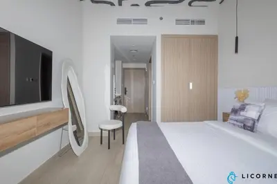 a hotel room with a bed and a tv at Modern Contemporary Studio in Azizi Riviera in Dubai