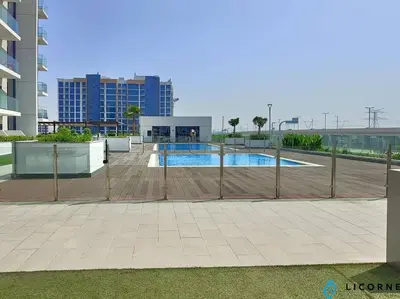 a fence around a swimming pool in a building at Modern Contemporary Studio in Azizi Riviera in Dubai