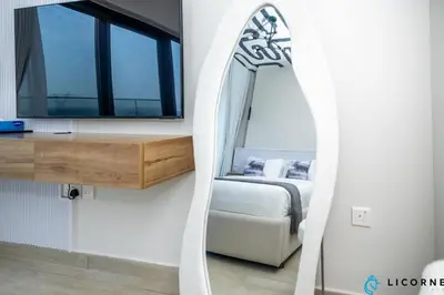 a mirror in a room with a bed and a window at Modern Contemporary Studio in Azizi Riviera in Dubai