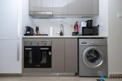 a kitchen with a stove and a washing machine at Modern Contemporary Studio in Azizi Riviera in Dubai