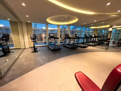 a gym with a row of tread machines in a building at Luxury 3BR Burj Khalifa View Infinity Pool Spa Gym in Dubai