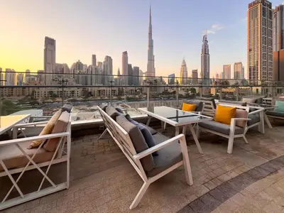 a rooftop patio with chairs and tables and a view of the city at Luxury 3BR Burj Khalifa View Infinity Pool Spa Gym in Dubai
