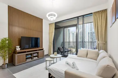 a living room with a large couch and a tv at Stunning 1BDR with Resort Style in Creek Harbour in Dubai