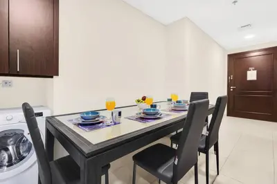a kitchen with a dining table and chairs and a laundry room at FIRST CLASS 1BR Charming Marina Escape in Dubai