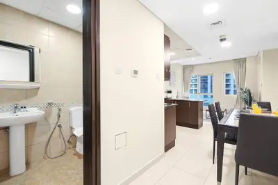 a bathroom and a kitchen with a sink and a table at FIRST CLASS 1BR Charming Marina Escape in Dubai