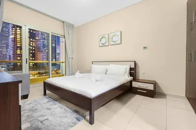 a bedroom with a large bed and a large window at FIRST CLASS 1BR Charming Marina Escape in Dubai