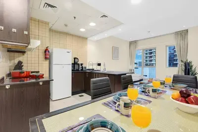 a kitchen with a table with a bowl of fruit on it at FIRST CLASS 1BR Charming Marina Escape in Dubai
