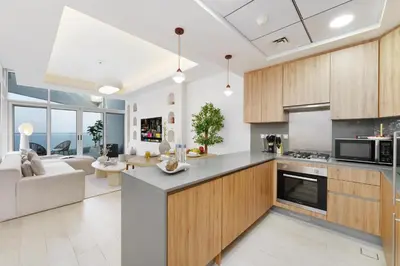 an open kitchen and living room with a couch at Dejaview Stays Luxury Apartment with Private Terrace, Burj & Sea View in Dubai