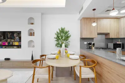 a kitchen and dining room with a table and chairs at Dejaview Stays Luxury Apartment with Private Terrace, Burj & Sea View in Dubai