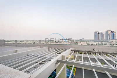 a view of the roof of a building with a city in the background at Chic Studio in Damac Hills Carson B, Dubailand by Deluxe Holiday Homes in Dubai