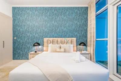 a bedroom with a large bed with a blue wall at Chic Studio in Damac Hills Carson B, Dubailand by Deluxe Holiday Homes in Dubai