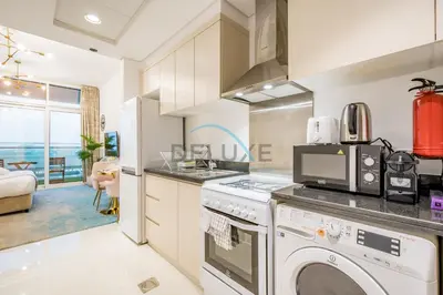 a kitchen with a washer and dryer at Chic Studio in Damac Hills Carson B, Dubailand by Deluxe Holiday Homes in Dubai