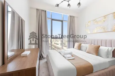 a bedroom with a large bed and a large window at Cozy 2-Bedroom Apartment in Fawad Azizi Residence in Dubai