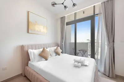 a bedroom with a white bed with a large window at Cozy 2-Bedroom Apartment in Fawad Azizi Residence in Dubai