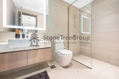a bathroom with a toilet and a glass shower at Cozy 2-Bedroom Apartment in Fawad Azizi Residence in Dubai