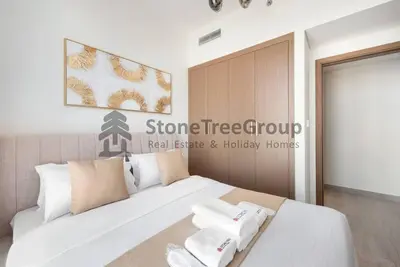 a bedroom with a white bed with towels on it at Cozy 2-Bedroom Apartment in Fawad Azizi Residence in Dubai