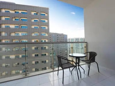 a table and chairs on a balcony with a view of a building at Cozy Studio Business Bay in Dubai