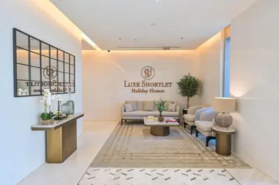 a waiting room with a couch and a table at Stylish 1BR by the Lagoon in District One Meydan in Dubai