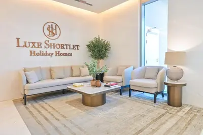 a living room with two couches and a coffee table at Stylish 1BR by the Lagoon in District One Meydan in Dubai